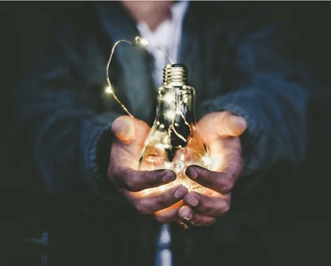 Person holding light bulb in their hands
